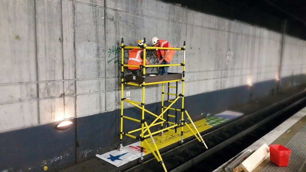 Image of two trained workers using an access tower, that has been constructed properly and is safe to use.