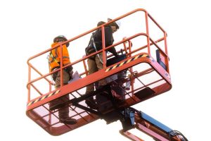 Two man working at high in a cherry picker wearing safety harnesses.